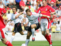 Steven Gerrard holds off the challenge from Wrexham's Danny Williams during the pre season friendly at the Racecourse 